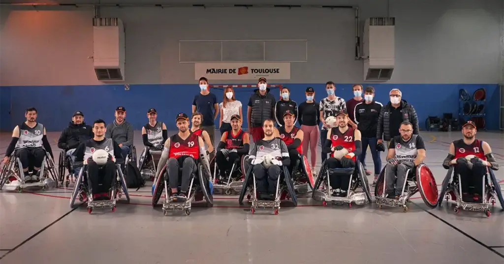 Équipe de quad rugby du Stade Toulousain Rugby Handisport avec joueurs en fauteuil et staff technique, gymnase de la Mairie de Toulouse